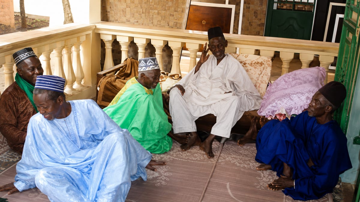 Assemblée traditionnelle : hommes en boubous réunis sur des nattes